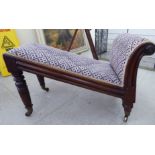 A late George III mahogany showwood framed gout stool with a scrolled end and angled top,