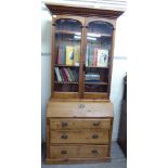 A late 19thC waxed pine, two part, bureau bookcase, comprising a pair of glazed panelled doors,