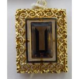 A 1960s gold coloured metal rectangular filigree wire framed pendant,