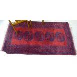 A Persian rug with five central octagonal motifs, bordered by stylised designs,