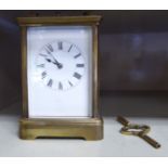 A mid 20thC lacquered brass cased carriage clock with bevelled glass panels and a folding top