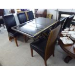A modern brushed steel and smoked plate glass topped dining table,