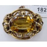 A gold coloured metal framed oval brooch, set with a citrine,