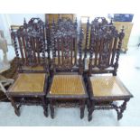 A set of six early 20thC Jacobean style carved oak framed dining chairs,
