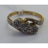 A 9ct gold and platinum three stone crossover diamond ring 11