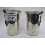 A pair of silver beakers with flared,