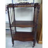 An early Victorian rosewood serpentine front whatnot with a fretworked gallery, over two undertiers,