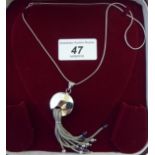 An 18ct white gold pendant necklace, comprising a disc with tassels,