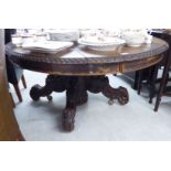 An early 20thC oak pedestal table, the planked oval top over a bulbous ring turned column,