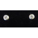 A pair of white metal rubover set diamond stud earrings 11