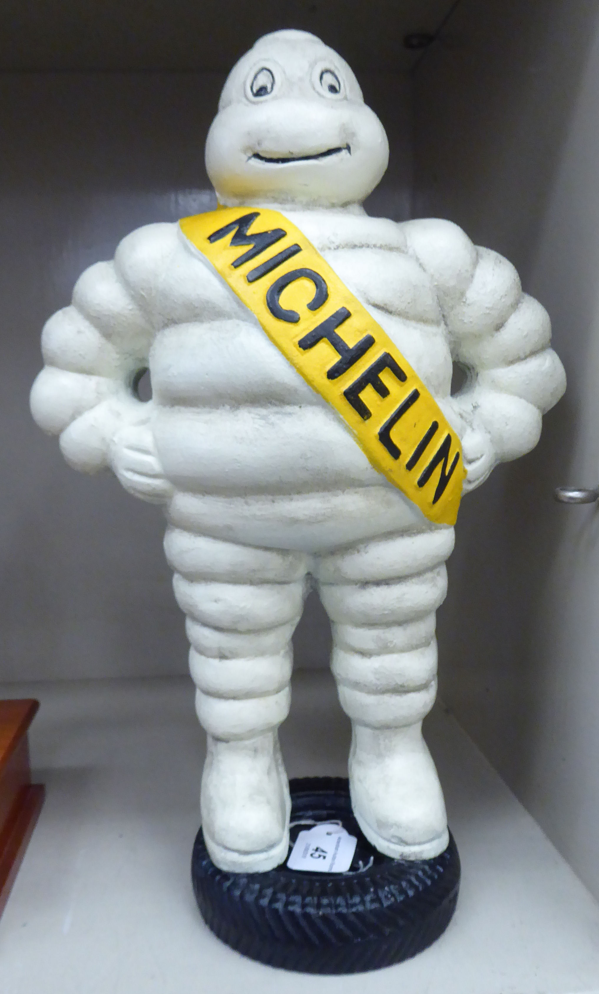 A painted cast iron figure, the Michelin Man standing on a tyre 14.