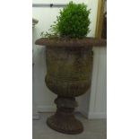 A pair of 19thC style cast iron campana design terrace pedestal urns,