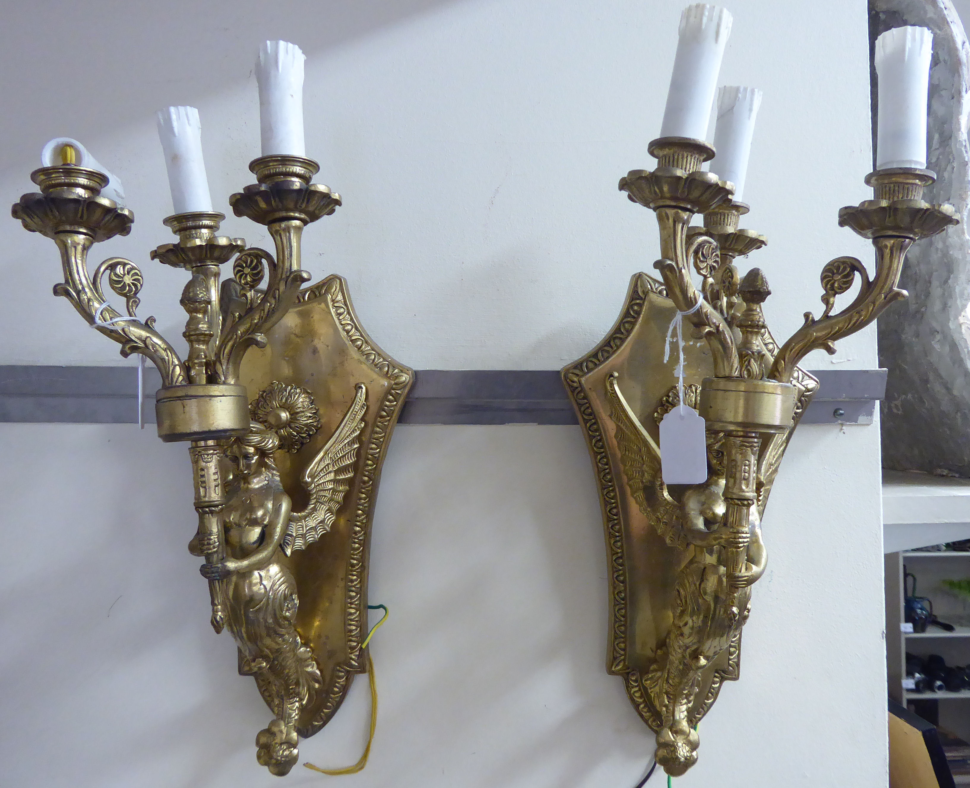 A pair of modern lacquered cast brass appliques with three candle style sconces,