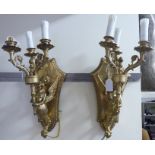 A pair of modern lacquered cast brass appliques with three candle style sconces,