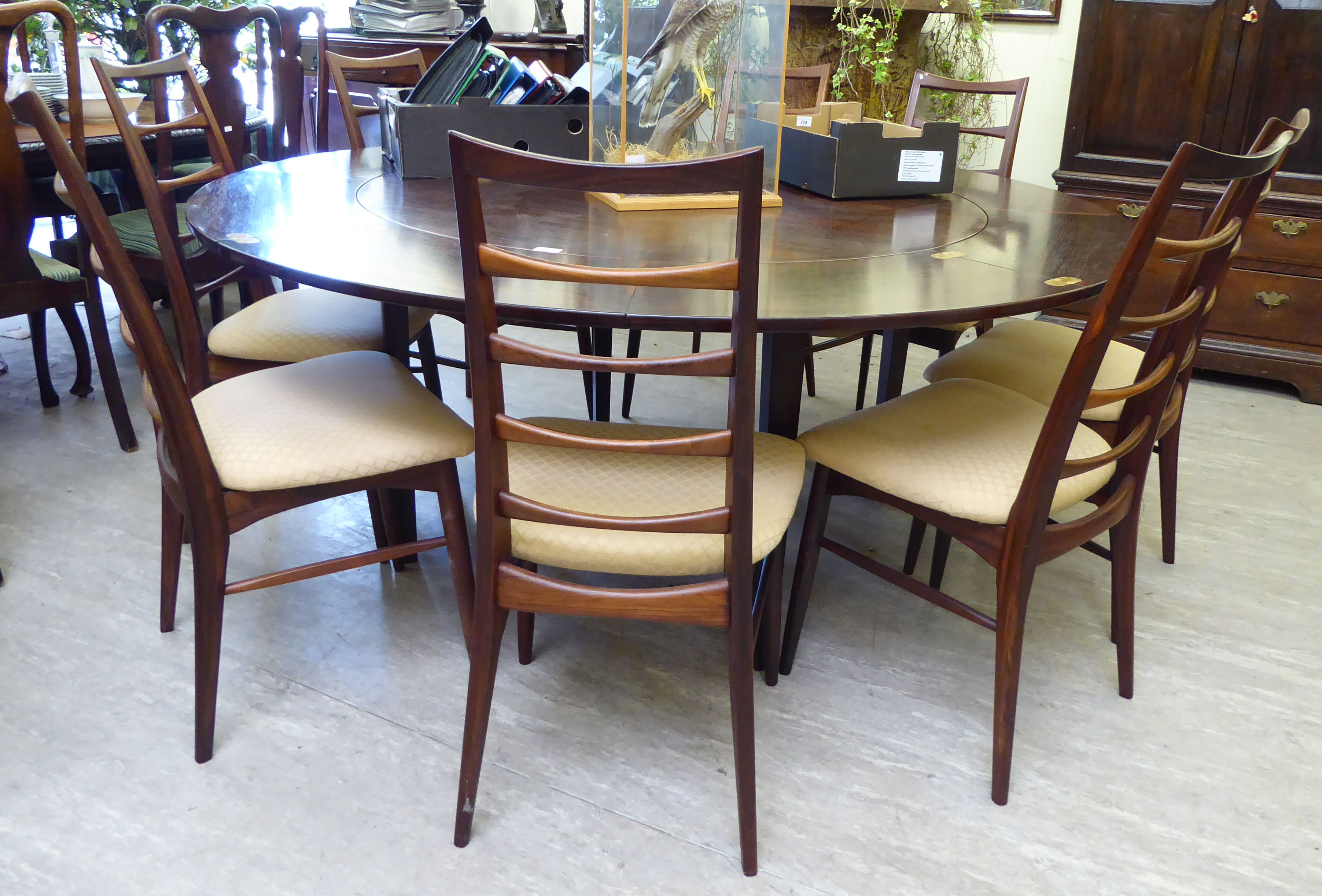 A 1960s Dyrlund rosewood flip-flap (or lotus) expanding dining table, incorporating four hidden,