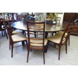 A 1960s Dyrlund rosewood flip-flap (or lotus) expanding dining table, incorporating four hidden,