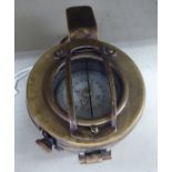 A reproduction of a World War II brass marching compass OS3