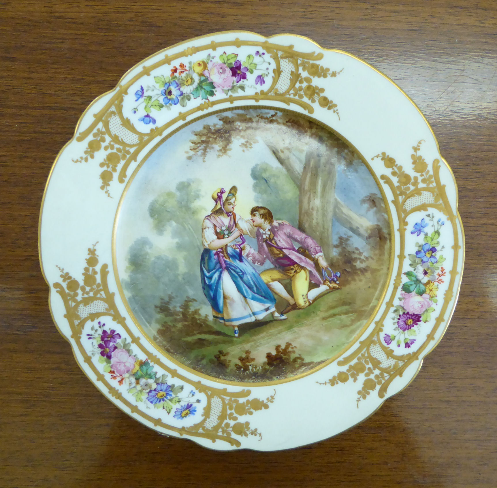 A mid 19thC Sevres porcelain wavy edge plate, featuring a romantic scene,