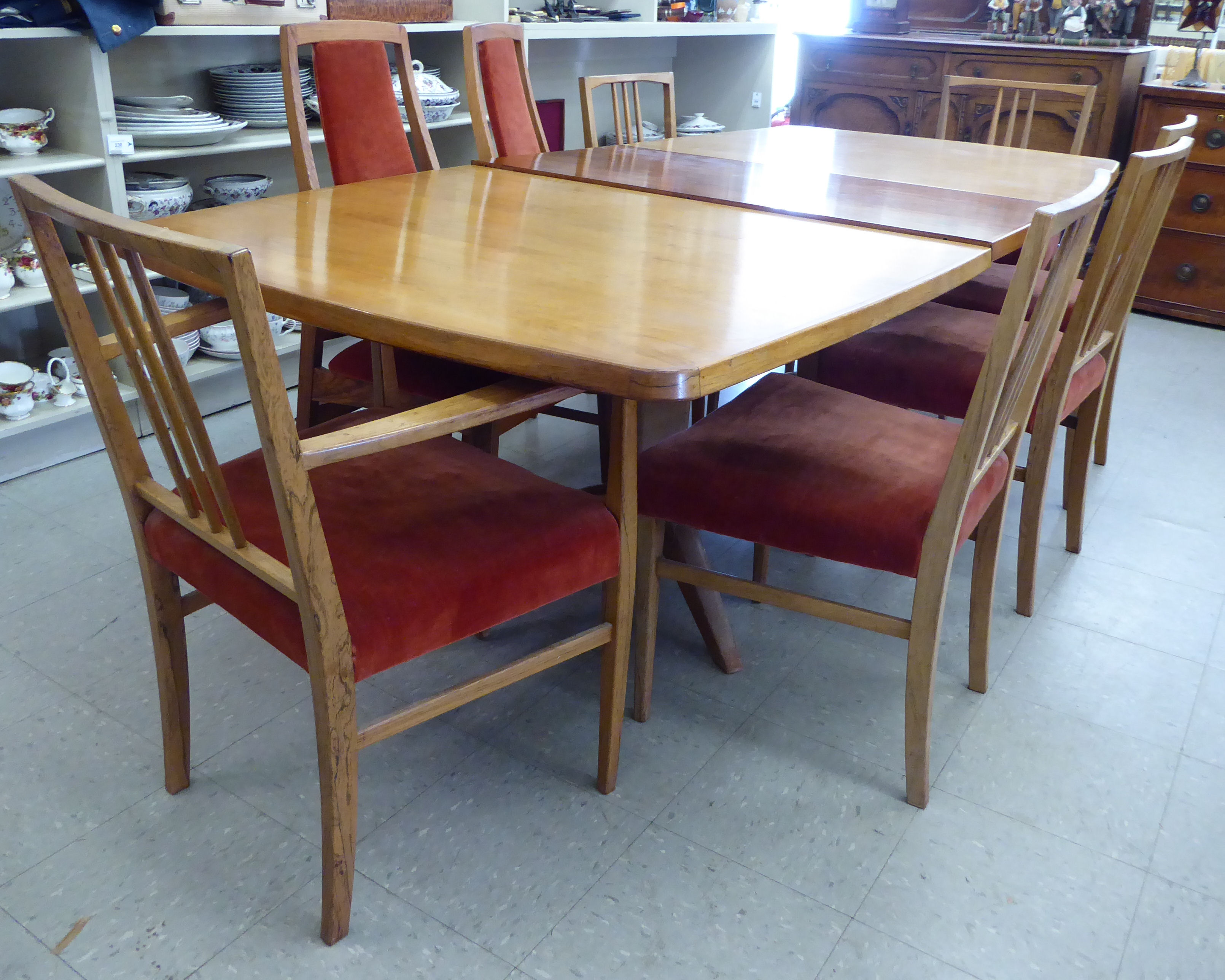 A modern rosewood dining table, the top with rounded corners, raised on a splayed underframe,