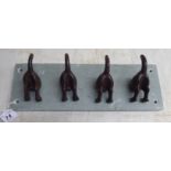 A cast iron novelty coat rack, fashioned as four dog tails,