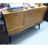 A mid 20thC light oak sideboard with an arrangement of fall flaps, drawers and doors,