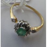 A 9ct gold cluster ring, set with a central emerald,