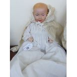 An early 20thC German bisque head doll with painted features and fixed eyes,