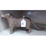 An early 20thC silver painted cast iron novelty nutcracker, in the form of a standing dog,