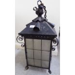 A mid 20thC Arts and Craft inspired black painted wrought metal porch lantern with mottled glass