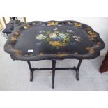 A late Victorian tray table, the serpentine outlined, black lacquered,