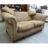 A modern two seater settee, upholstered in stylised brown fabric, raised on turned,