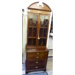 An Edwardian string inlaid mahogany cabinet with a broken arch pediment, over two glazed doors,
