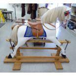 A modern piebald carved and painted wooden nursery rocking horse, on a trestle stand with a mane,