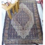 A Persian rug with a central diamond shaped motif,