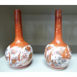 A pair of early 20thC Satsuma earthenware vases with long, narrow necks,
