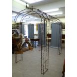 A Victorian style wrought steel terrace pergola, comprising a pair of arches,