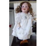 An early 20thC SFBJ bisque head doll with painted features and weighted sleeping eyes,