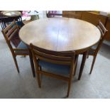 A 1970s teak extending dining table, the top with rounded ends,