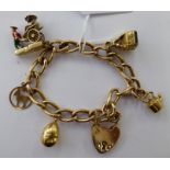 A 9ct gold charm bracelet with five 9ct gold pendants and a heart shaped clasp 11