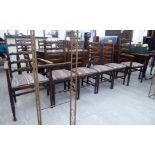A set of four 1930s oak framed ladderback dining chairs, each with a drop-in seat,