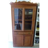 A late Victorian pitch pine cupboard with a pair of glazed doors,