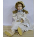 An early 20thC French bisque head doll with painted features and weighted sleeping eyes,