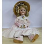 An early 20thC German bisque head doll with painted features and weighted sleeping eyes,