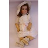 An early 20thC SFBJ bisque head doll with painted features and weighted eyes,