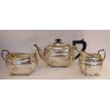 A matched three piece silver tea set of panelled, oval,
