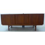 A 1960s Swedish teak sideboard, comprising three full height, horizontally sliding doors,