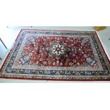 An Oriental rug with a central floral starburst motif,