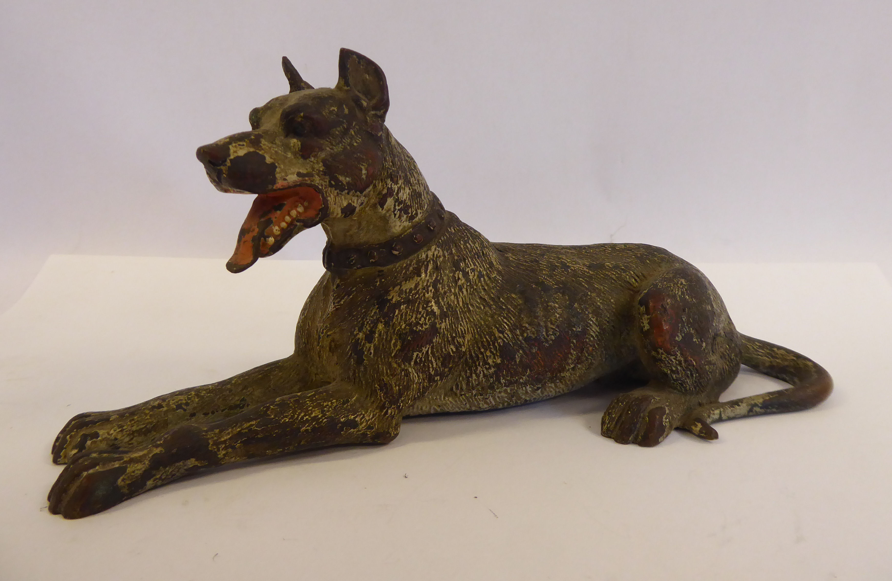 An early 20thC painted cold cast bronze model, a seated dog (possibly a Doberman),