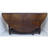 A late 18thC Country made oak gateleg table, the planked oval top raised on a ring turned,