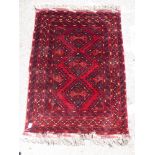 An Afghan rug with three diamond head motifs,